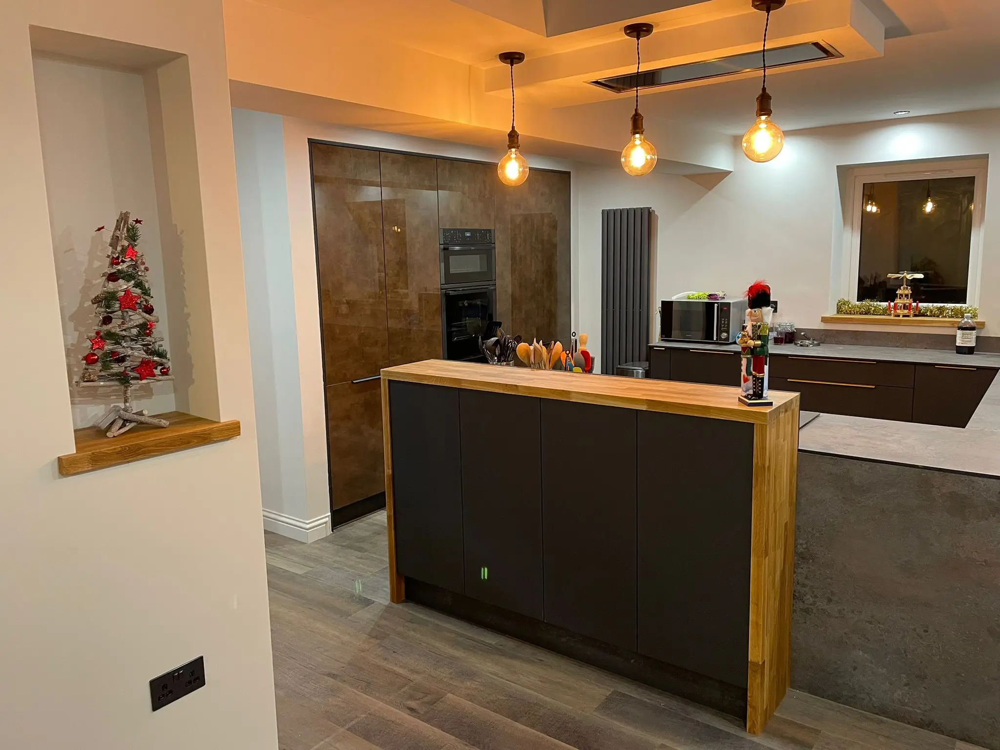Kitchen island with solid oak breakfast bar under three filament pendants