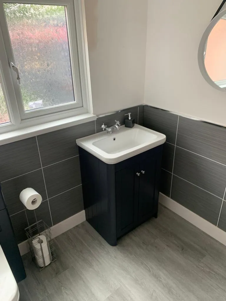 Cloakroom with navy traditional vanity and grey wood-strip half-height tiling